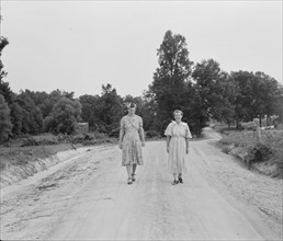 Women walking down the road to see a sick neighbor. Person County, North Carolina.