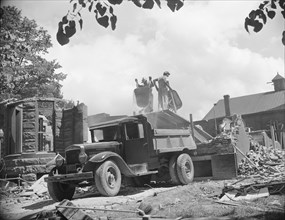 Washington, D.C. Loading debris from wrecked buildings along Independence Avenue.