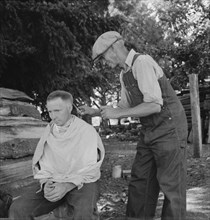 Oregon, Marion County, near West Stayton. Bean pickers barber each other.