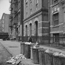 New York, New York. Street scene showing open trash cans along the curb.