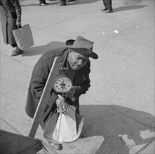 New York, New York. Street peddler in Harlem weighing string beans.