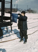 John Paulinski, car inspector, blue flagging a train for inspection, Corwith yard, Chicago, 1943. Creator: Jack Delano.