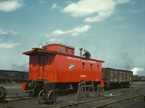 C & NW RR putting the finishing touches on a rebuilt caboose..., Proviso yard, Chicago, Ill., 1943. Creator: Jack Delano.