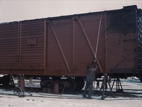 Painting a car at the repair or "rip" tracks at North Proviso(?), C & NW RR, Chicago, Ill., 1942. Creator: Jack Delano.
