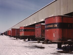 Truck trailers line up at a freight house to load and unload goods...C & NW RR, Chicago, Ill., 1942. Creator: Jack Delano.
