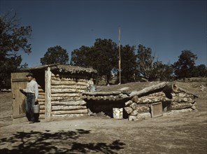 Mr. Leatherman, homesteader, coming out of his dugout home, Pie Town, New Mexico, 1940. Creator: Russell Lee.
