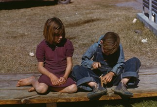 Boy building a model airplane as girl watches, FSA ... camp, Robstown, Tex., 1942. Creator: Arthur Rothstein.