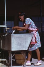 Young woman at the community laundry on Saturday afternoon, FSA ... camp, Robstown, Tex., 1942. Creator: Arthur Rothstein.