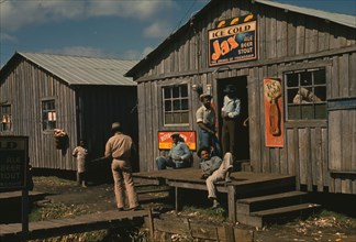 Living quarters and "juke joint" for migratory workers, a slack season; Belle Glade, Fla., 1941. Creator: Marion Post Wolcott.