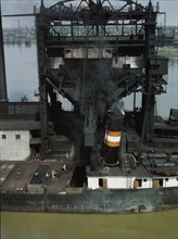 Loading coal into a lake freighter at the Pennsylvania Railroad docks, Sandusky, Ohio, 1943. Creator: Jack Delano.