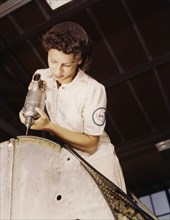 A rivet is her fighting weapon..., Naval Air Base, Corpus Christi, Texas, 1942. Creator: Howard Hollem.