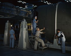 Putting the nose section of a mighty transport...Consolidated Aircraft..., Fort Worth, Texas, 1942. Creator: Howard Hollem.