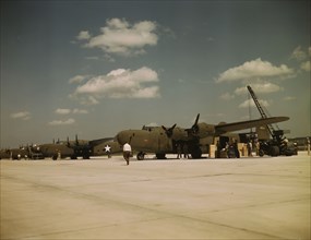 Loading new transport planes at the Consolidated Aircraft Corporation plant, Fort Worth, Texas, 1942 Creator: Howard Hollem.