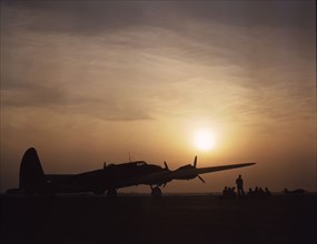Sunset silhouette of flying fortress, Langley Field, Va., 1942. Creator: Alfred T Palmer.