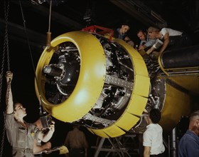 Mounting motor on a Fairfax B-25 bomber, North American Aviation, Inc., Inglewood, Calif., 1942. Creator: Alfred T Palmer.
