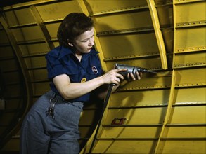 Operating a hand drill at Vultee-Nashville, woman is working on a "Vengeance" dive..., Tenn., 1943. Creator: Alfred T Palmer.