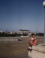 Little girl in a park with Union Station in the background, Washington, D.C., ca. 1943. Creator: Unknown.