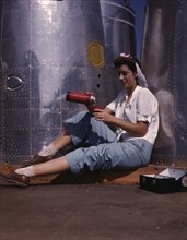 Girl worker at lunch also absorbing Calif..., Douglas Aircraft Company, Long Beach, Calif., 1942. Creator: Alfred T Palmer.