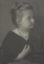 Portrait of a girl with a necklace clasping a shawl, c1900.
