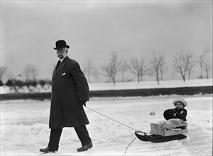 Skating Party - Unidentified Man Pulling Child On Sled, 1912.