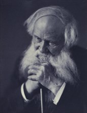 Elderly man clasping a cane(?), head-and-shoulders portrait, c1900.