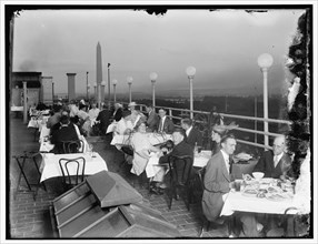 Dining on rooftop; Washington monument in background, between 1910 and 1920.
