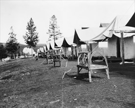 Tourist accommodations in Upper Geyser Basin, Yellowstone Park, 1903. Tents and rustic log benches. (Wyoming).