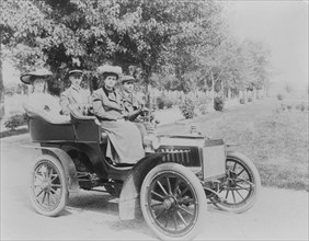 Frances Benjamin Johnston seated with three other people in automobile, between 1890 and 1910.