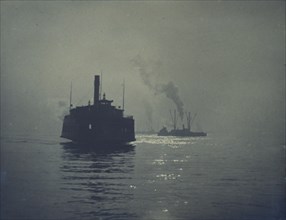A ferry crossing a smooth body of water with other ships in the background, c1900.