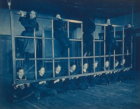 Female students posing with exercise equipment in a gymnasium, Western High School, Washington, D.C., (1899?).