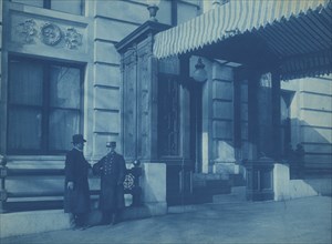 Two men, one a doorman, standing at the F. Street entrance to the Willard Hotel, between 1901 and 1910.