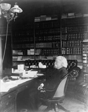 Melville Weston Fuller, full-length portrait, seated at desk, facing left, c1899. Creator: Frances Benjamin Johnston.