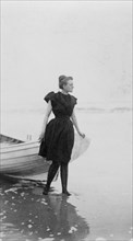 Frances Benjamin Johnston, full-length portrait, standing at edge of ocean, in..., c1880 - 1900. Creator: Unknown.