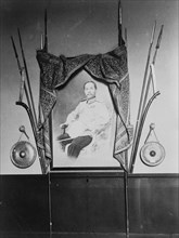 Display with portrait of a man, possibly Chulalongkorn, King of Siam, in Siam exhibit..., 1904. Creator: Frances Benjamin Johnston.
