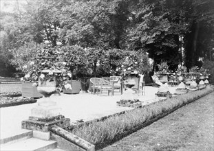 A Shaded gravelled terrace, screened by orange trees, with chaise longues..., France, 1925. Creator: Frances Benjamin Johnston.