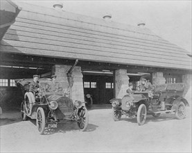 Four men with two automobiles outside of garage of Edmund Cogswell..., Greenwich, Connecticut, 1908. Creator: Frances Benjamin Johnston.