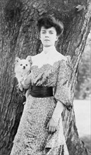 Alice Roosevelt Longworth, three-quarter length portrait, standing in front of tree...dog, c1902. Creator: Frances Benjamin Johnston.