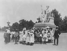 Group of school children in front of statue of George Washington, Washington, D.C., (1899?). Creator: Frances Benjamin Johnston.