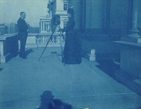 Frances Benjamin Johnston on a balcony of the State, War and Navy Building with a tripod..., 1888. Creator: Frances Benjamin Johnston.