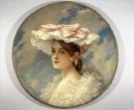 La charlotte d'Alphonsine, 1905. Woman in hat decorated with ribbons.