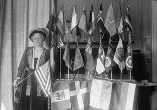 Mrs. Carrie Chapman Catt with Flags of 22 Nations, 1917. Creator: Harris & Ewing.