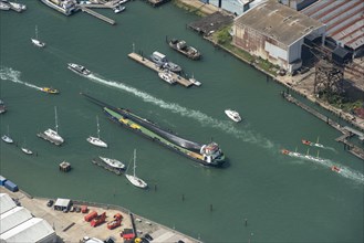A wind turbine blade aboard Blade Runner Two, a shallow water barge, on the River Medina, Cowes, Isle of Wight, 2021.