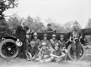 Group of Boy Scouts Posed with Dog And Three Men in Front of An Automobile, between 1914 and 1917.