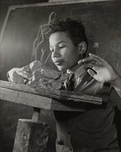 Boy sculpting, Harlem Art Center, 1939.