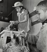 Girl and boy sculpting, Harlem Art Center, 1939.