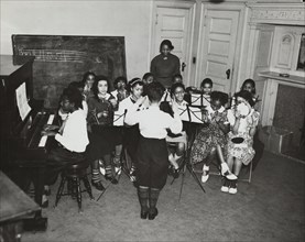 Music classes, tambourines and piano, 1938.