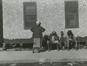 Two African American men and one African American boy sitting and one African..., Jan 1939. Creators: Farm Security Administration, Marion Post Wolcott.
