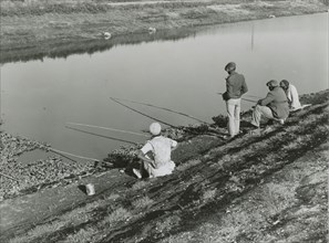 African American migrant laborers fishing in Belle Glade, Florida, January 1939.