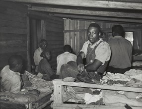 Negroes in bunkhouse in strawberry fields near Hammond, Louisiana; Note crude..., April 1939. Creators: Farm Security Administration, Russell Lee.