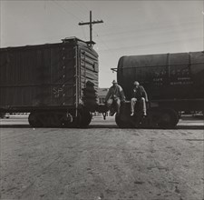 Colored itinerants on oil tank cars passing through Kingsbury, California, 1938.